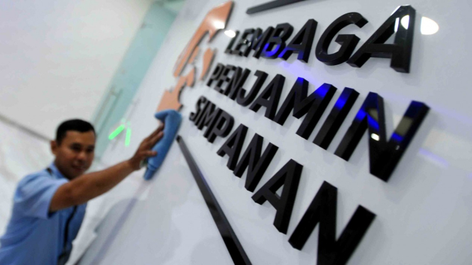 Karyawan membersihkan logo baru Lembaga Penjamin Simpanan (LPS) di Jakarta