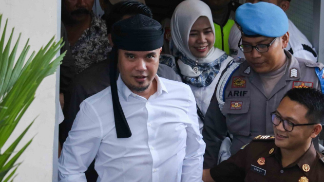 Ahmad Dhani Prasetyo (kiri) saat berjalan menuju mobil tahanan usai mengikuti sidang di Pengadilan Negeri Surabaya, Jawa Timur.