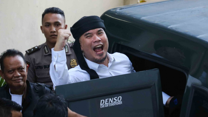 Terdakwa kasus dugaan pencemaran nama baik Ahmad Dhani Prasetyo (kanan) masuk ke mobil tahanan usai mengikuti sidang tuntutan di Pengadilan Negeri Surabaya, Jawa Timur