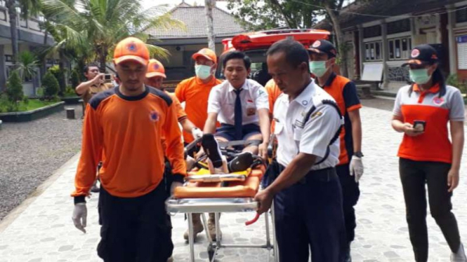 Aparat BPBD Kabupaten Jembrana, Bali, menggotong seorang siswa SMP untuk mengikuti UNBK di SMPN 3 Jembrana pada Rabu, 24 April 2019.