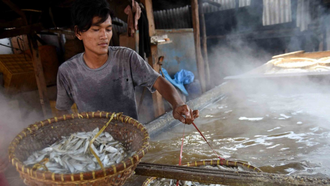 Pekerja memasak ikan yang diasinkan di sentra pengolahan ikan asin, Cilincing, Jakarta Utara, Selasa, 23 April 2019.