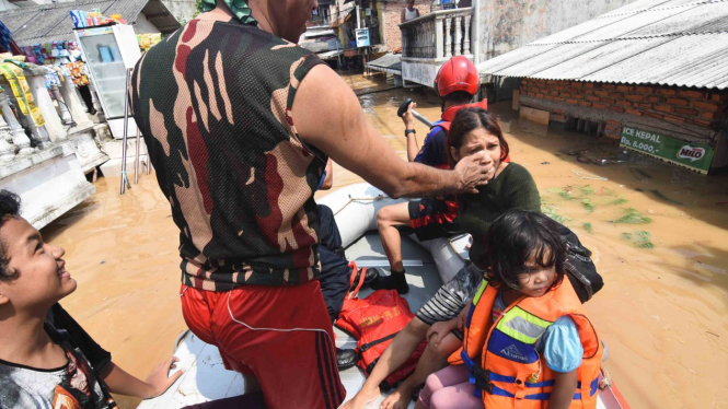 Petugas Damkar mengevakuasi warga terdampak banjir di kawasan Rawajati, Jakarta Selatan, Jum'at, 26 April 2019.