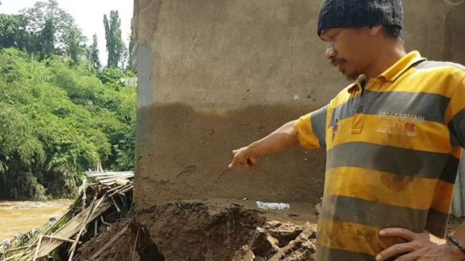 Nur, seorang warga Kota Depok, Jawa Barat, memperlihatkan bagian rumahnya yang hancur akibat derasnya luapan Kali Ciliwung pada Jumat, 26 April 2019.