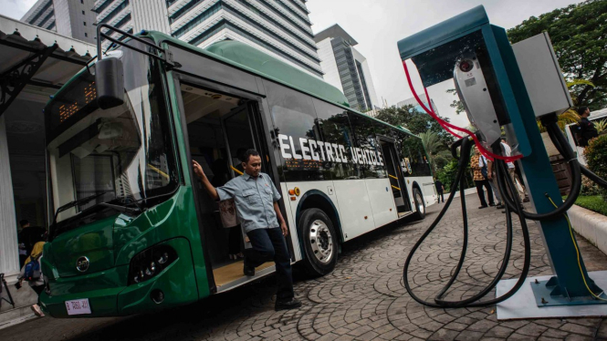 Penumpang turun dari bus listrik usai mengikuti uji coba di halaman Balai Kota Jakarta.
