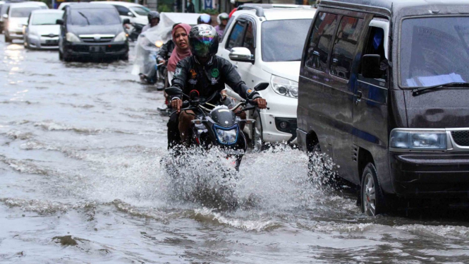 Pengendara kendaraan bermotor menerobos banjir yang menggenangi pusat Kota Lhokseumawe, Aceh