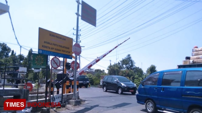 Jangan ditiru. Kendaraan terobos palang pintu KA saat mulai bergerak menutup. (FOTO: Pamula Yohar C/TIMES Indonesia)