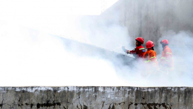 Petugas pemadam kebakaran berusaha memadamkan api yang melahap gudang sembako, di kawasan Aren Jaya, Bekasi, Jawa Barat