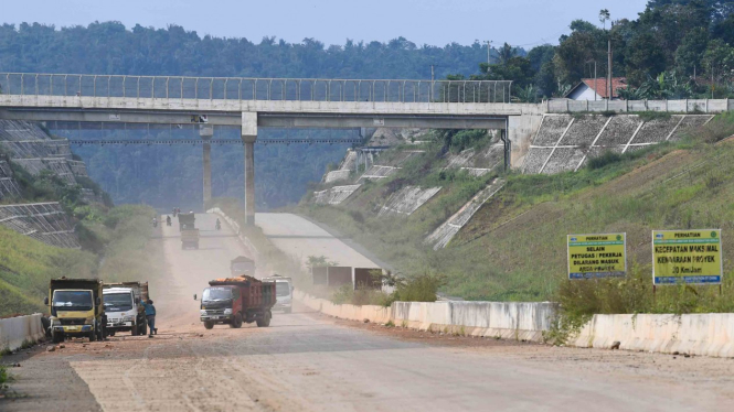 Sejumlah truk melintasi proyek pembangunan Jalan Tol Cileunyi-Sumedang-Dawuan (Cisumdawu) di Kabupaten Sumedang, Jawa Barat, Rabu, 8 Mei 2019.