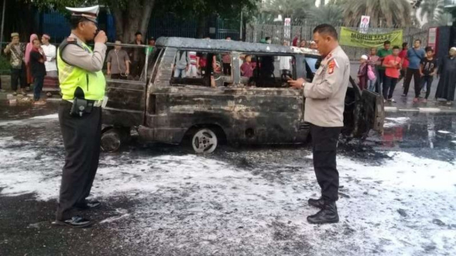Polisi menangani mobil Carry yang terbakar di depan Masjid Istiqlal.