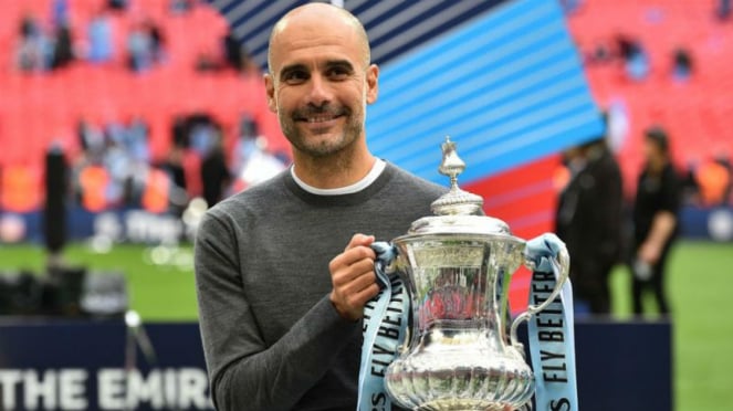 Manajer Manchester City, Pep Guardiola, bersama trofi Piala FA