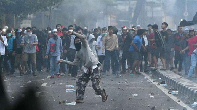 Bentrok antara massa dengan polisi.