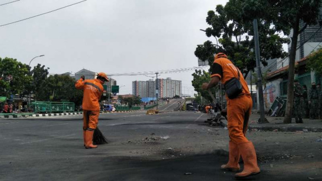 Petugas PPSU membersihkan jalan di kawasan Jakarta Pusat.