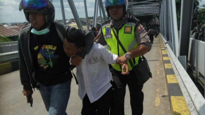 Polisi menangkap orang-oran yang diduga terlibat dalam kericuhan disertai perusakan dan pembakaran sebuah pos polisi di Pontianak, Kalimantan Barat, pada Rabu, 22 Mei 2019.