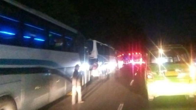 Bus-bus antarkota dan antarprovinsi terparkir di bahu jalan sambil menunggu calon penumpang pemudik sehingga menyebabkan macet Jalan Raya Serang, Curug, Tangerang, Banten, Kamis malam, 30 Mei 2019.