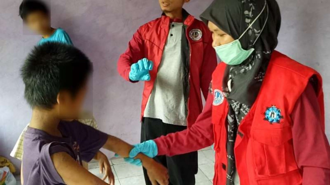 Petugas medis memeriksa seorang anak dari satu keluarga yang terserang penyakit menyerupai cacar dan dikhawatirkan cacar monyet di Kabupaten Bogor, Jawa Barat, pada Kamis, 30 Mei 2019.