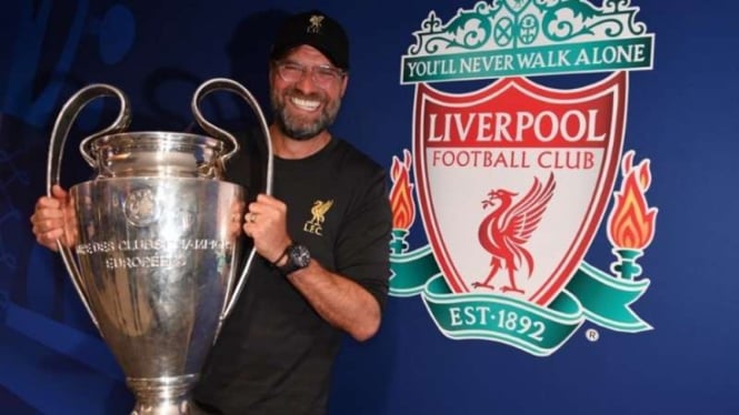 Manajer Liverpool, Juergen Klopp, memegang trofi Liga Champions