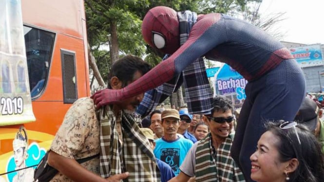 Spiderman bagi-bagi sarung di Solo, Jawa Tengah, Senin, 3 Juni 2019.