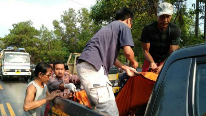 Petugas mengevakuasi jasad pengendara motor yang tergilas truk di Serang.