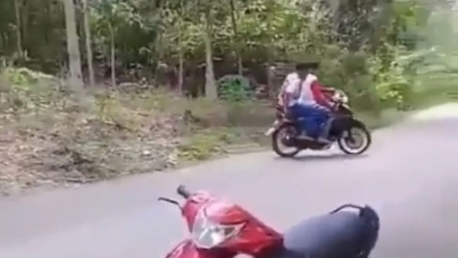 Pemuda berboncengan di motor