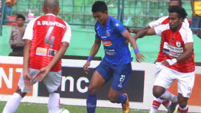 Pemain Arema FC, Dedik Setiawan (tengah) saat melawan Persipura Jayapura.