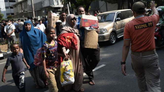 Pencari suaka menunggu giliran saat akan dipindahkan ke Jakarta Barat.