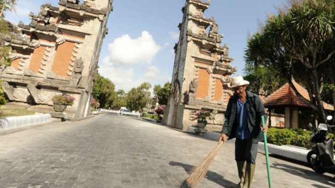 Petugas membersihkan puing-puing bangunan gapura gerbang masuk kawasan The Nusa Dua yang runtuh akibat gempa di Badung, Bali, Selasa (16/7/2019). 