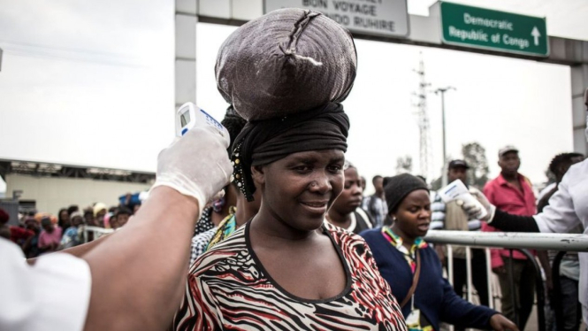 Seorang perempuan diperiksa suhu tubuhnya di pos pemeriksaan Ebola ketika dia memasuki Rwanda dari Kongo.-Getty Images