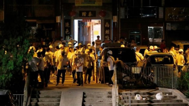 Sekelompok pria bertopeng yang dipersenjatai tongkat menyerbu stasiun kereta api di distrik Yuen Long, Hong Kong, Minggu.-Reuters