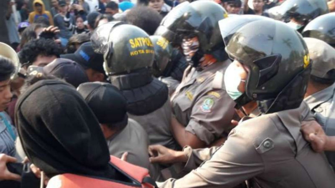 Bentrokan antara warga dengan aparat Satuan Polisi Pamong Praja dalam penggusura