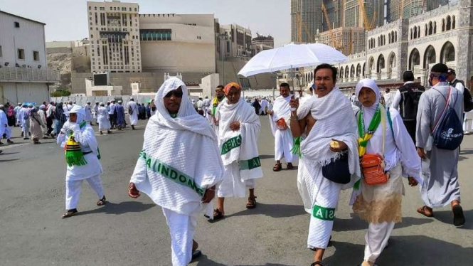 Jemaah haji menggunakan payung menghindari cuaca panas di Kota Mekah