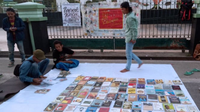 Sejumlah anggota komunitas vespa leterasi saat membuka lapak baca gratis di alun-alun Kraksaan, Kabupaten Probolinggo. (FOTO: Istimewa)