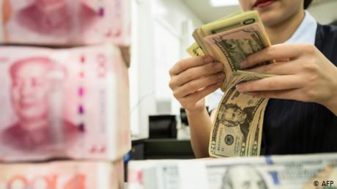 Seorang pedagang valuta asing sedang menghitung uang dolar AS.-AFP
