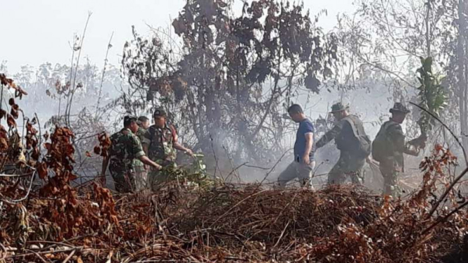 Aparat TNI bersama Kepolisian dan BPBD berusaha semampunya memadamkan kebakaran hutan.