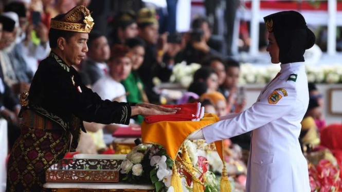Presiden Joko Widodo menyerahkan duplikat bendera pusaka kepada Paskibraka Tarrisa Maharani Dewi saat Upacara Peringatan HUT RI ke-74 di Istana Merdeka Jakarta, Sabtu (17/8/2019). 