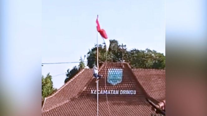 Yudha, siswa kelas XII MIPA 5 SMA Dringu, Kabupaten Probolinggo, Jawa Timur saat memanjat tiang bendera untuk membenahi Bendera Merah Putih yang nyangkut  saat Upacara Penurunan Bendera di kantor Kecamatan Dringu, Sabtu (17/8/2019) (FOTO: Istimewa)