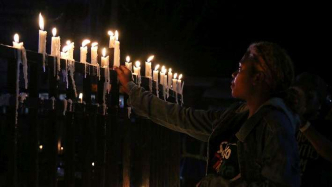 Warga Papua menyalakan lilin saat aksi damai di Bundaran Tugu Perdamaian Timika Indah, Mimika, Papua, Senin (19/8/2019). Pemblokiran internet di Papua untuk mencegah penyebaran hoax terkait kerusuhan masih diterapkan pemerintah. 