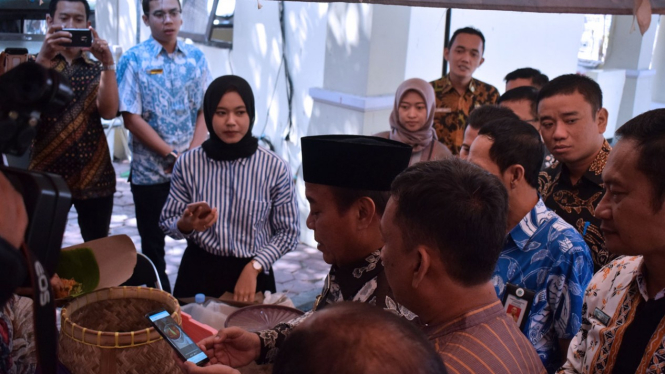 Bupati Lamongan, Fadeli menjajal barcode LA Pay untuk pembayaran nasi boran, Selasa, (20/8/2019). (FOTO: Ardiyanto/TIMES Indonesia)