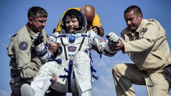 Anne McClain dibantu keluar dari kapsul ruang angkasa setelah kembali dari ISS bulan Juni lalu - Reuters.