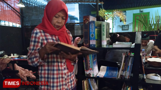 Salah satu pengunjung tengah khusuk membaca buku di Cafe Melati di Jalan Kamboja Pamekasan.(Foto: Akhmad Syafi"i/TIMES Indonesia)