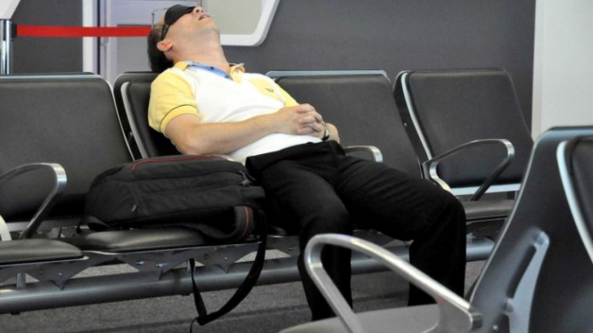 A traveller sleeps in Sydney Airport.