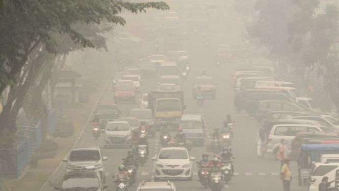Pengendara kendaraan bermotor menembus kabut asap pekat dampak dari kebekaran hutan dan lahan di Pekanbaru, Riau, Jumat (13/9/2019). Masyarakat di Provinsi Sumatera Utara kini juga terpapar kabut asap. 