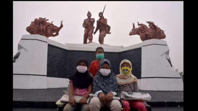 Bocah penjual koran pakai masker saat kabut asap di Pekanbaru Riau (14/9/2019)