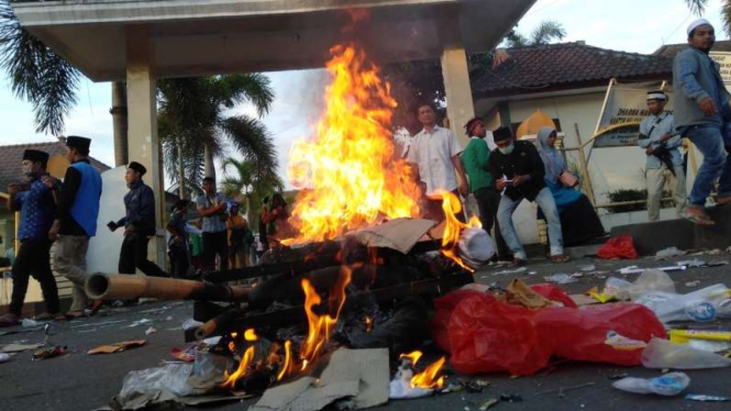 Massa membakar ban dan keranda di depan kantor Kemenkum HAM NTB.