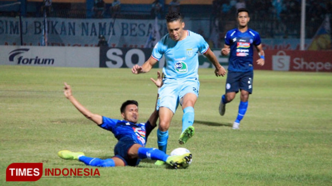Pemain belakang Arema FC, Alfin Tuasalamony (biru) berupaya menghentikan aksi Rafael Gomes Oliveira, Jum"at (20/9/2019). (FOTO: MFA Rohmatillah/TIMES Indonesia)