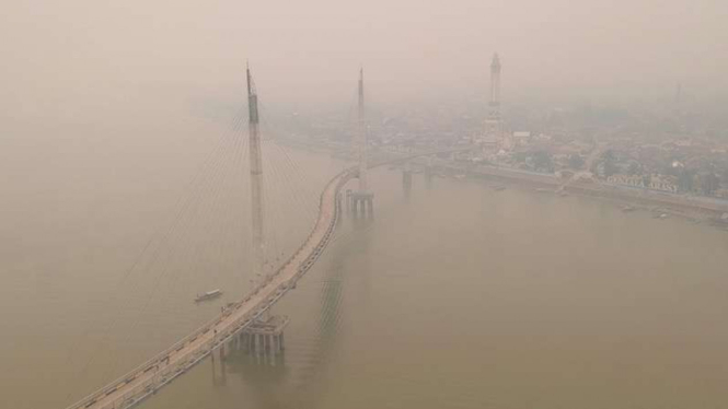 Foto udara Sungai Batanghari yang diselimuti kabut asap dari karhutla di Jambi, Sabtu (21/9/2019). Kota Jambi kembali terpapar kabut asap yang bertambah pekat dalam dua hari terakhir. 