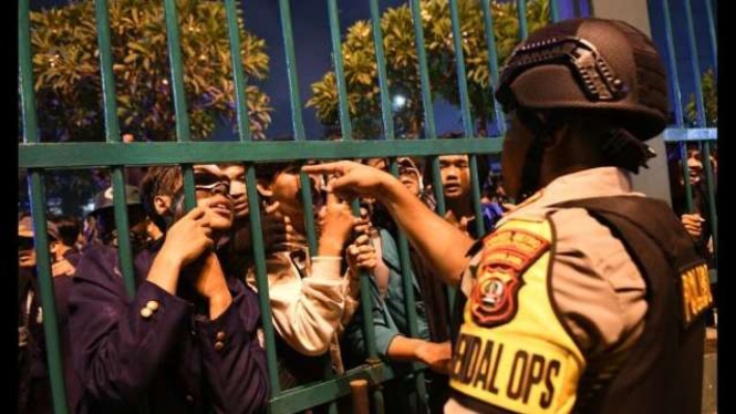 Seorang Polisi berbincang dengan massa mahasiswa yang berunjuk rasa di depan kompleks Parlemen, Jakarta, Senin (23/9/2019) malam. Ribuan mahasiswa yang berasal dari kampus se-Jabodetabek turun ke jalan berdemonstrasi menolak UU KPK dan pengesahan RUU KUHP