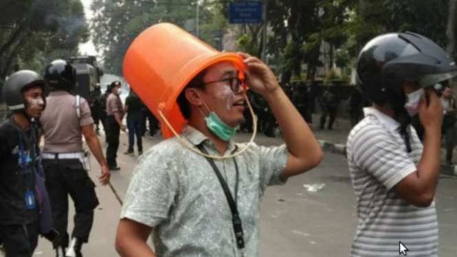 Dedi Rizki Ginting memakai ember sebagai helm saat ricuh demo mahasiswa di Medan.