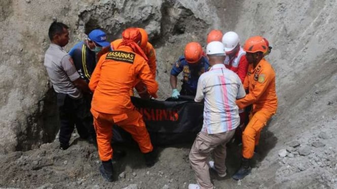 Tim SAR gabungan mengevakuasi jenazah Matheis Frans warga Desa Nania yang tewas tertimbun longsoran bukit pasir di Desa Nania, Ambon, Maluku, Kamis (26/9/2019). Bukit pasir tersebut longsor akibat gempa bumi magnitudo 6,5 yang mengguncang Pulau Ambon. 