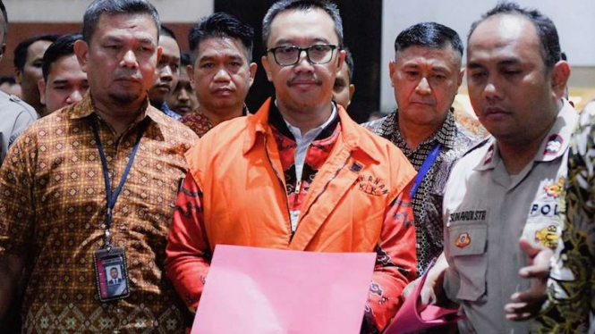 Mantan Menteri Pemuda dan Olahraga Imam Nahrawi (tengah) mengenakan rompi orange usai menjalani pemeriksaan di Gedung KPK Jakarta, Jumat, (27/9/2019). 