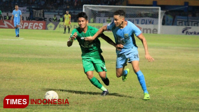 Pemain Persela, Rafael Gomes Oliveira (biru muda), mendapat kawalan ketat dari pemain belakang Bhayangkara FC, I Putu Gede Juni Antara, Sabtu (28/9/2019). (FOTO: MFA Rohatillah/TIMES Indonesia)